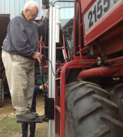 Alvin Blaha using a hydraulic platform lift to access the cab of his International 2555 Cotton Picker