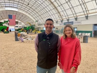 Roberto Franco stands beside Addie Johnson inside a farm days exhibit hall.